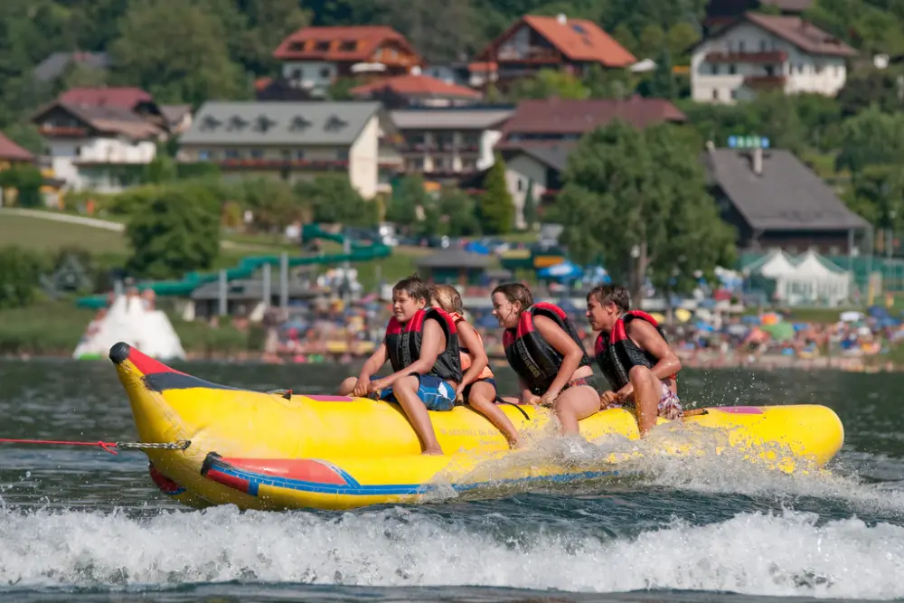 Kinder fahren Bananenboot am Faaker See